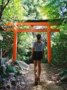 Travellerin Lisa vor einem roten Torii auf Miyajima